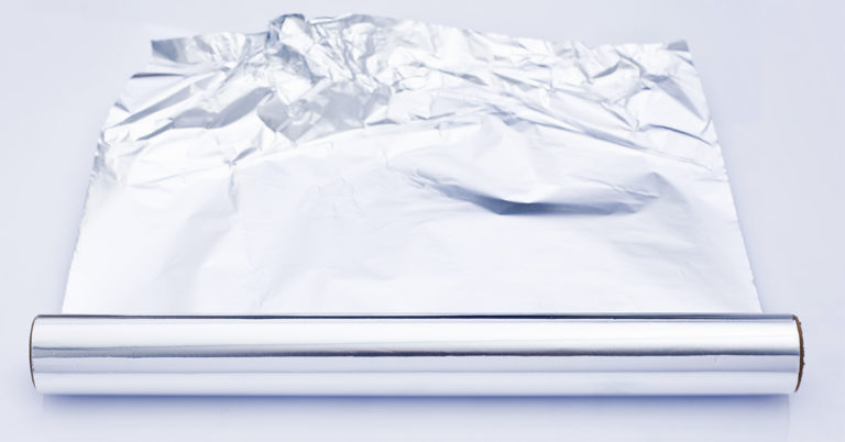 Mother puts tin foil on dinner table to avoid using the dishwasher - Featured image