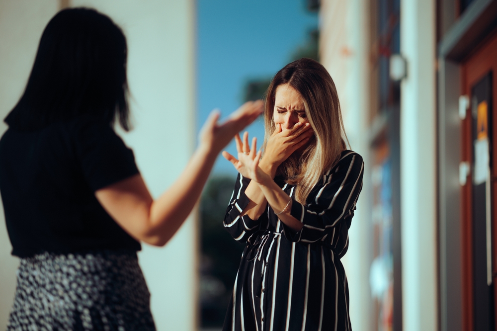 Woman Crying Fighting with Her Best Friend Outdoors. Unhappy emotional girl disagreeing with her sister