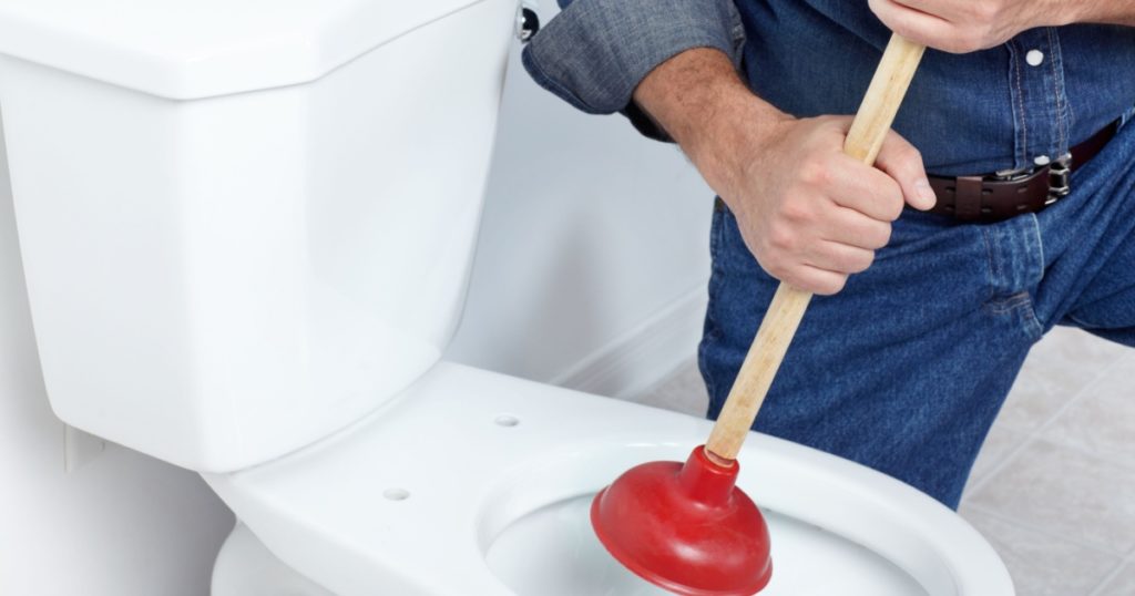 Plumber with a toilet plunger