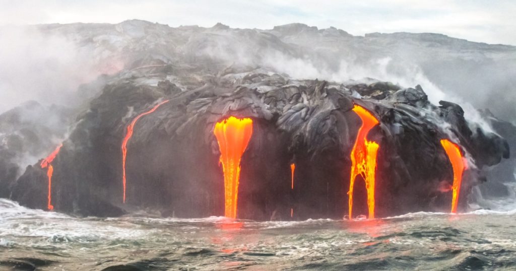 Close up of Kilauea Volcano, Hawaii Volcanoes National Park, also known Kilauea Smile because from 2016 seems to smile, erupting lava into Pacific Ocean, Big Island. Scenic sea view from the boat.