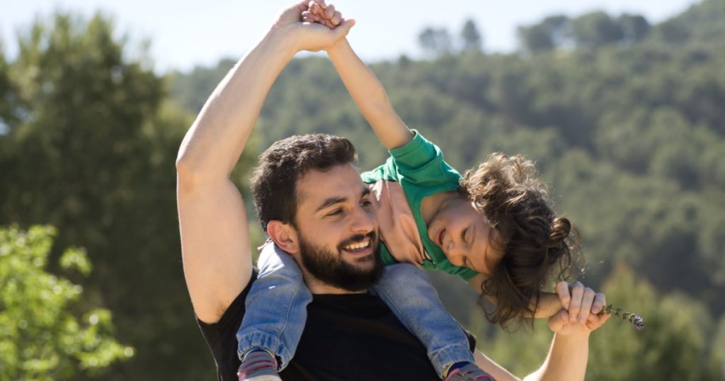 Bearded father and baby girl playing outdoors. Happy image of single father