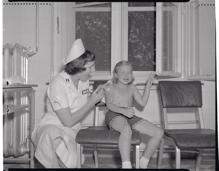 A nurse giving a polio vaccine.