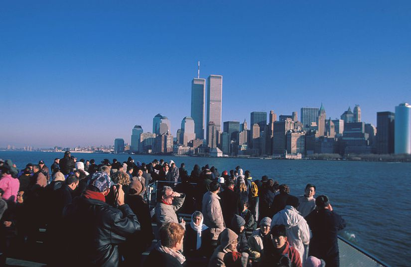 People looking at the Manhattan skyline, including the World Trade Center.