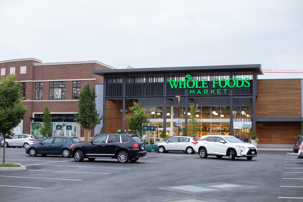 Bellevue, Washington / USA - July 7 2019: Wide angle view of a Whole Foods organic grocery store and parking lot, with space for text on top and bottom
