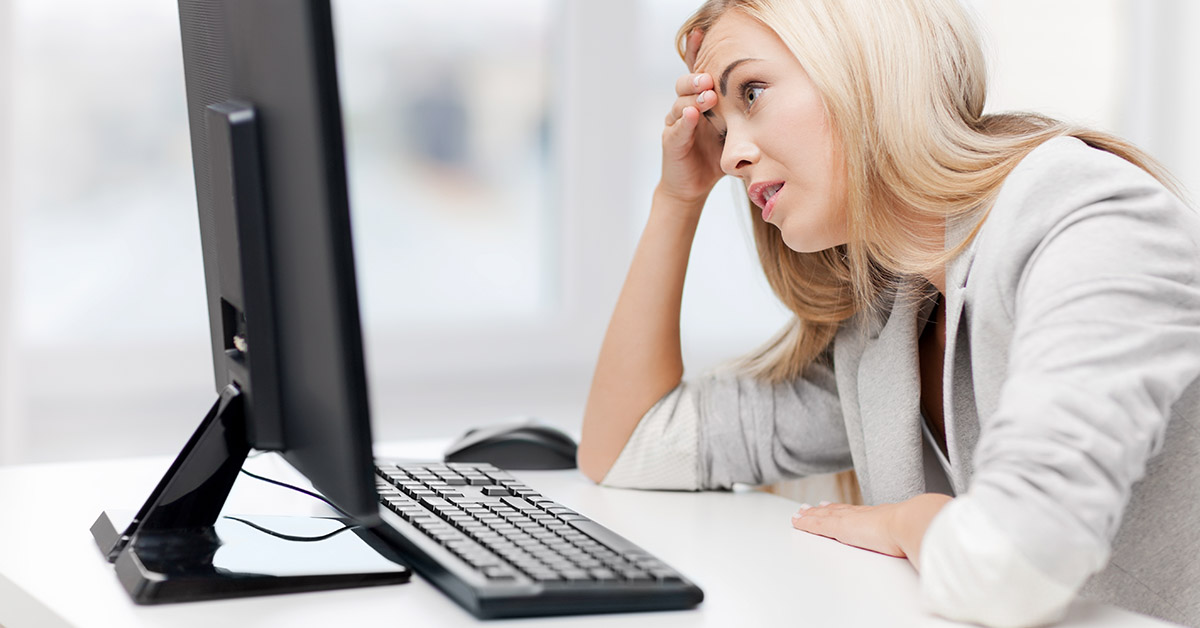woman looking confused while looking at computer screen