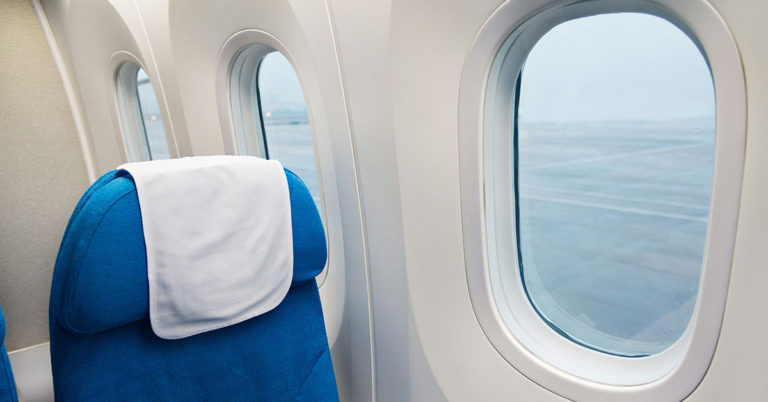 The Mystery of the Triangle Stickers Above Airplane Seats—What Do They Really Mean? - Featured image