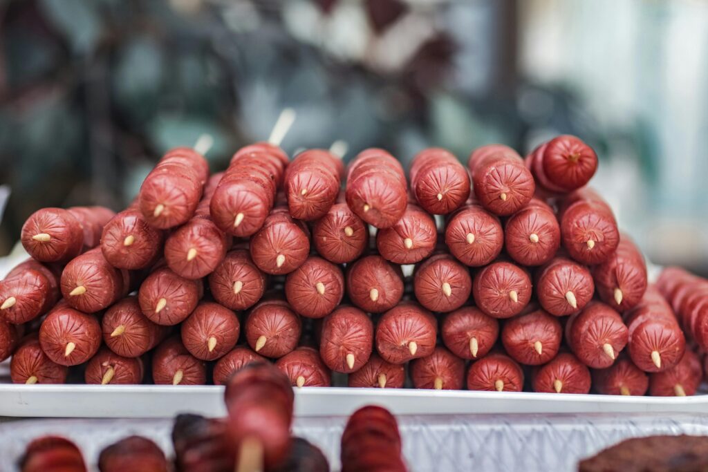 Close-Up Photo of Skewered Sausage on Tray
