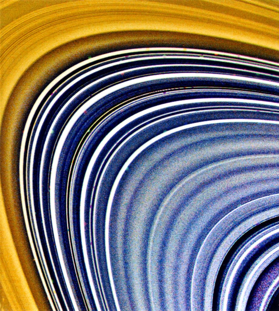 This view focusing on Saturn's C-ring (and to a lesser extent, the B-ring at top and left) was compiled from three separate images taken through ultraviolet, clear and green filters. On Aug. 23, when it acquired these frames, Voyager 2 was 2.7 million kilometers (1.7 million miles) from the planet. More than 60 bright and dark ringlets are evident here; the small, bland squares are caused by the removal of reseau (reference) marks during processing. In general, C-ring material is very bland and gray, the color of dirty ice. Color differences between this ring and the B-ring indicate differing surface compositions for the material composing these complex structures.