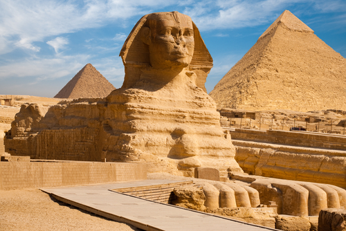 Beautiful profile of the Great Sphinx including pyramids of Menkaure and Khafre in the background on a clear sunny, blue sky day in Giza, Cairo, Egypt
