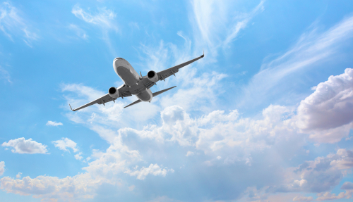 White passenger airplane flying in the sky amazing clouds in the background - Travel by air transport