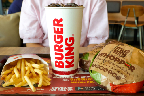 Bangkok, Thailand - 11 May 2019 : Burger king set has whopper hamburger french fries and cola drink in paper glass on wooden table in burger king restaurant.