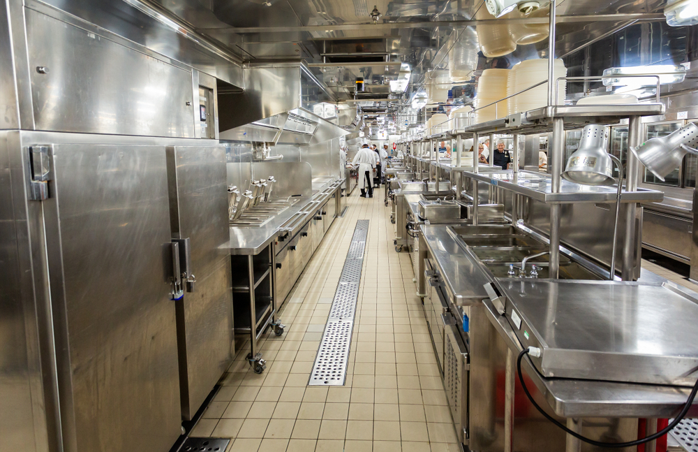 Behind the scenes view of food preparation in the kitchen, galley on board a large cruise ship at Sea in Queen Victoria in the Baltic Sea on 24 July 2019