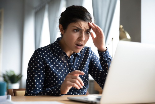 Shocked afraid worried young indian girl look at laptop computer screen terrified read bullying social media message feel bad surprise stress panic about stuck computer problem concept at home office
