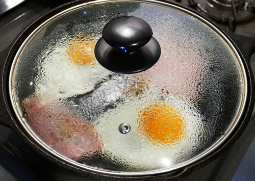 Put the lid on the frying pan to bake fried egg and bacon and steam it