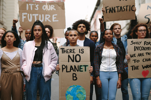 Group of activists with banners protesting to save earth. Men and women rebellions doing a silent protest over global warming and pollution.