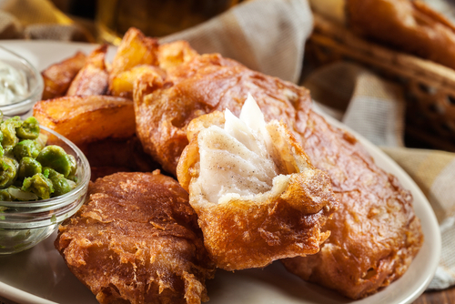 Traditional fish in beer batter and chips with green pea and tartar sauce
