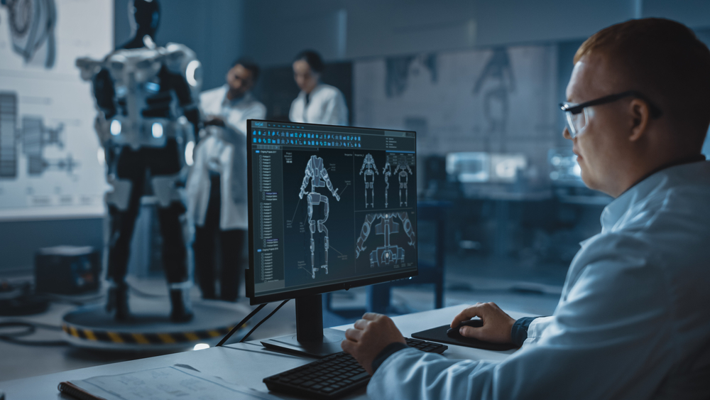In Robotics Development Laboratory: Chief Analyst Uses Computer for Designing Powered Exosuit to Help Disabled People. Top Engeneers and Scientists Work on Bionics Exoskeleton Prototype.