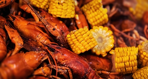 Street food. Casserole with red boiled crawfish and corn
