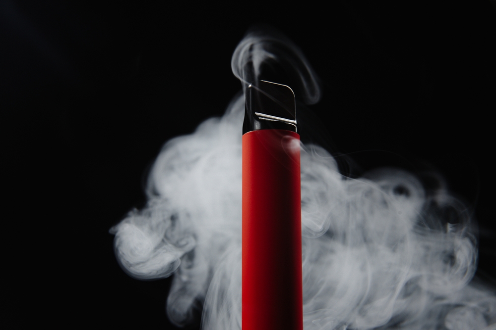 Colorful disposable e-cigarette, on a black background. The concept of modern smoking, vaping and nicotine. Alternative to smoking, safe cigarettes. How to quit smoking