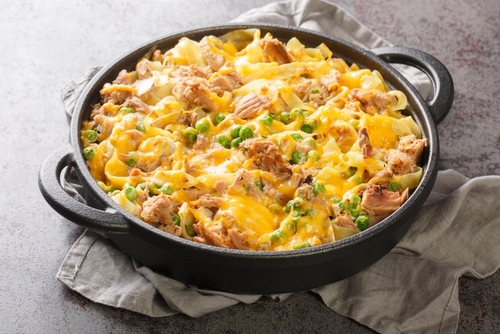 Homemade Cheesy Tuna Casserole with Peas and Egg Noodles closeup on the pan on the table. Horizontal
