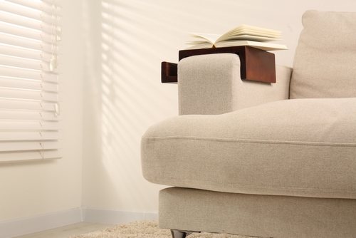 Interior of light living room with cozy grey sofas near big window