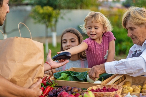 Grandmother and granddaughter sell vegetables and fruits at the farmers market. Selective focus. food.