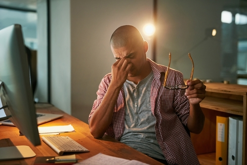 Computer, stress and man with headache in office for pressure, fatigue and deadline of article. Journalist, editor and person and pain at creative agency for digital report, brain fog and burnout