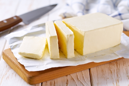 Sliced pieces of butter on a light table, selective focus. Piece of butter.
