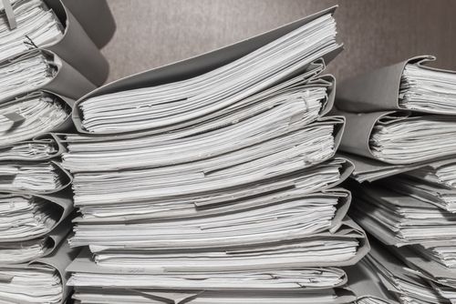 Paper documents stacked in archive. folders with documents on the shelves of archive room. Office shelves in the closet full of files