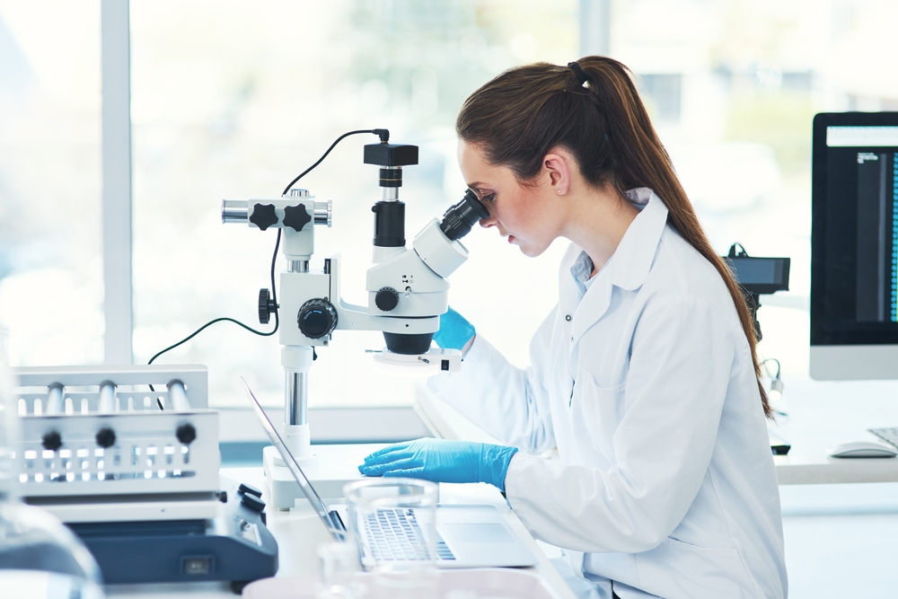 Woman, research and microscope at laboratory for bacteria with medical study, investigation and development. Female scientist, lab coat and science with testing for virus, disease and illness