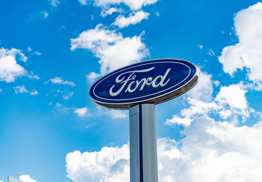 Chicago, USA - August 17, 2024: Ford logo sign against blue cloudy sky. Ford motor company is a oldest car company. Ford sign near dealership