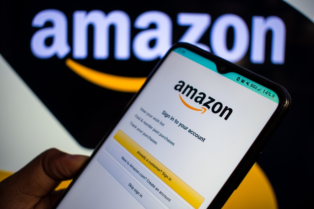 WASHINGTON, D.C. USA - NOV 23, 2024: A man holds a smartphone with the Amazon website on the screen on Nov 12, 2024, in Washington, DC, USA. Amazon is a US company owned by businessman Jeff Bezos.