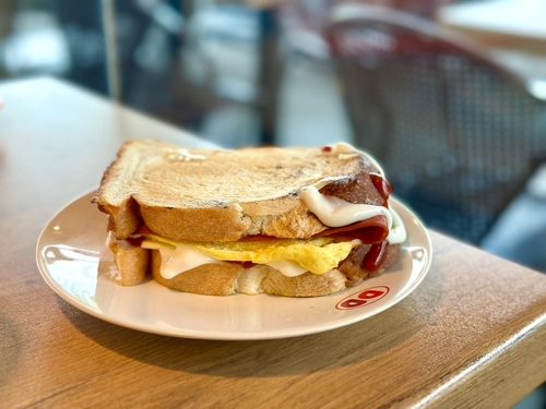 Dunkin' Toast filled with smoked beef, sunny-side-up egg, melted cheese, tomato sauce, and mayo – a savory delight in every bite! Cisauk, Indonesia - March 14, 2025