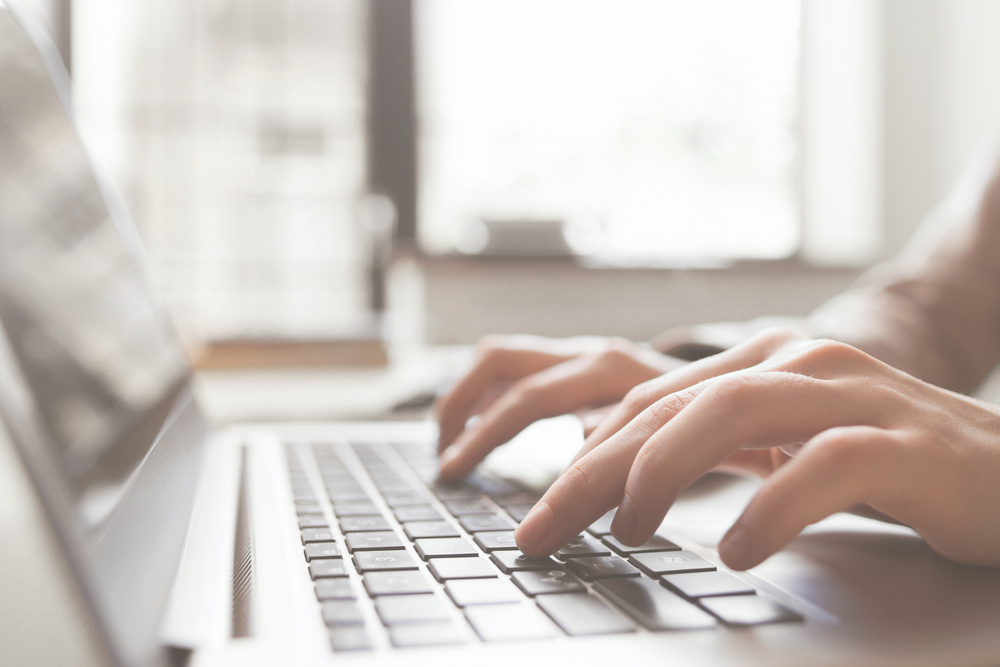 hands typing on laptop