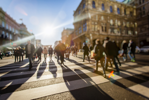 Crowd of anonymous people walking on busy city street