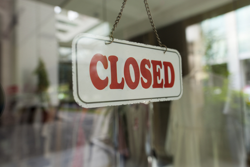 Close up shot of a closed sign hanging up on the glass door.