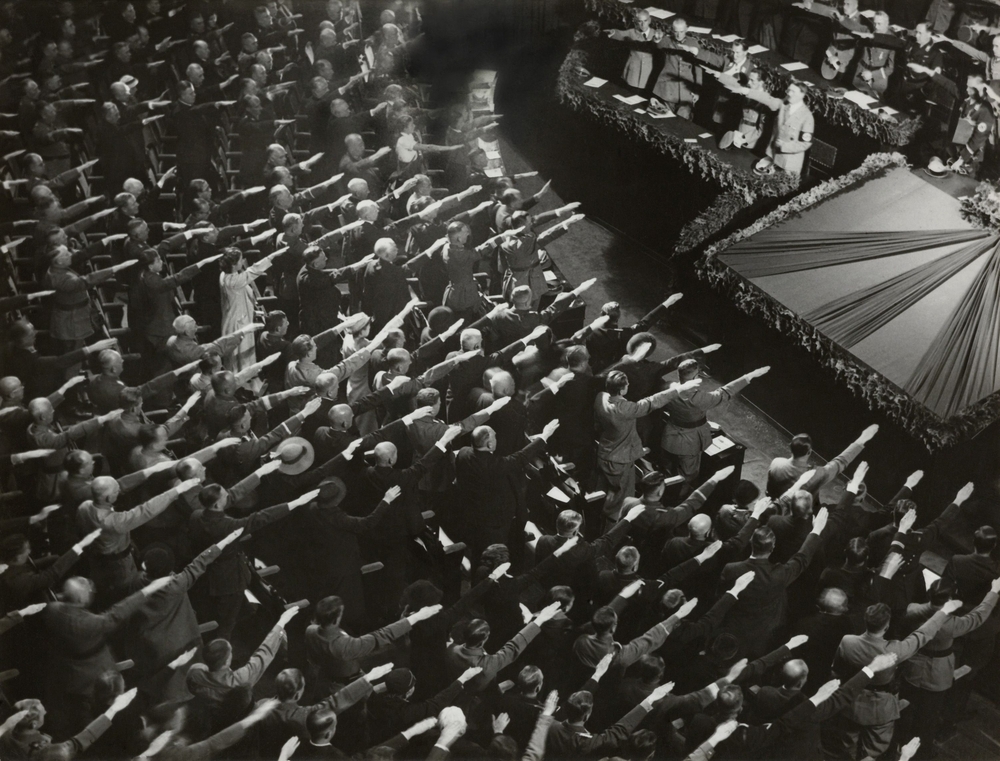 Attendees give Hitler the Nazi salute during the nation anthem, Oct. 9, 1935. They were meeting at the Kroll Opera in Berlin, to organize the Winter Relief festive to help finance charitable work