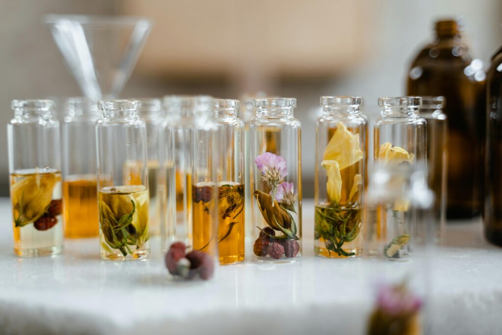 Small Clear Glass Bottles with Dried Flowers on White Table