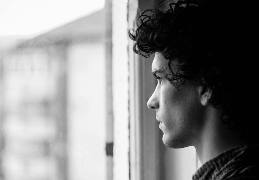 man looking out of window