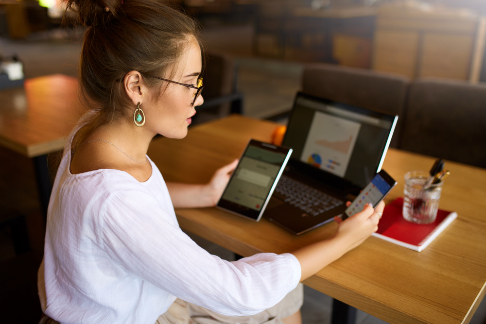 woman with electronics on desk