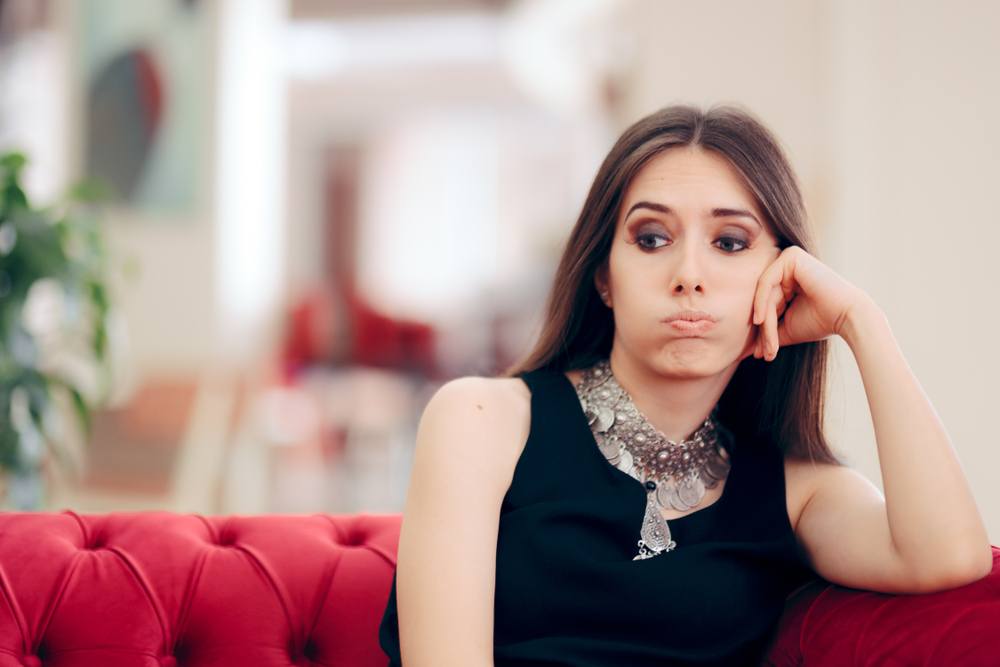 woman looking uncomfortable on the couch