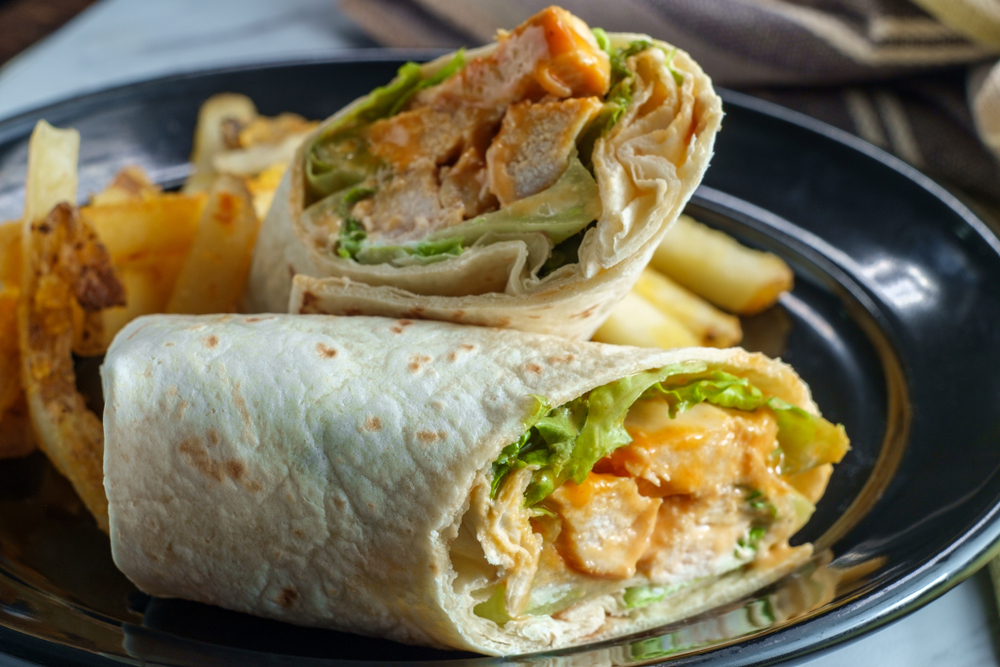 Grilled buffalo chicken sandwich wrap with romaine lettuce bleu cheese and fries