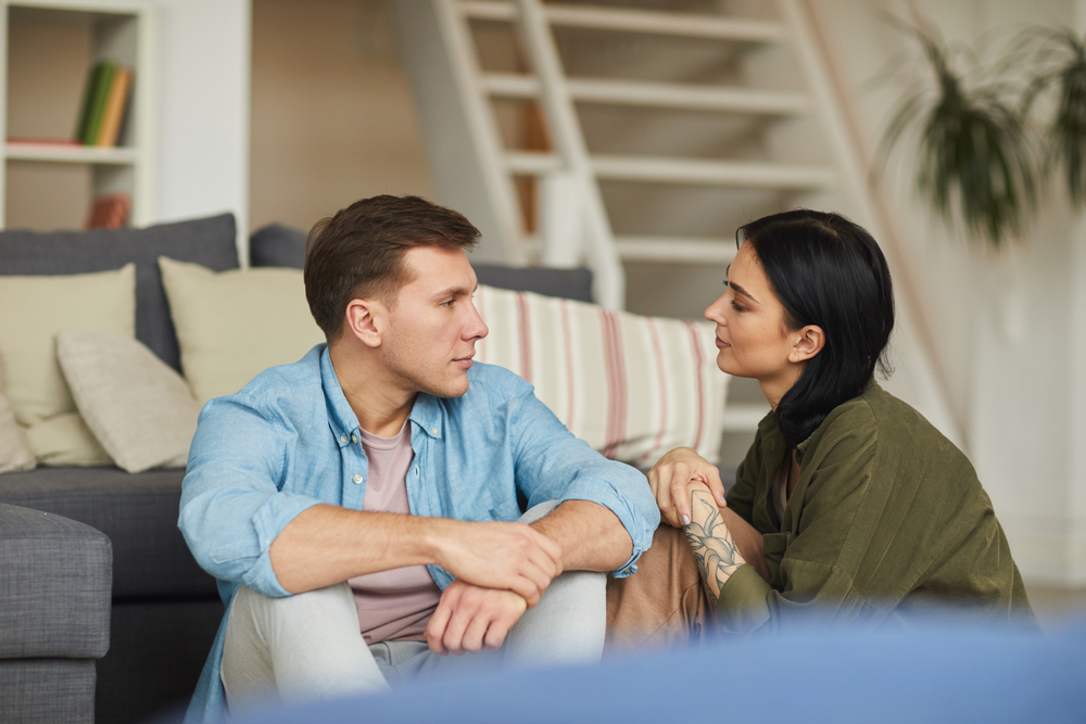 woman in green shirt talking to man