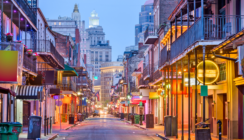 Bourbon St, New Orleans, Louisiana, USA cityscape of bars and restaurants at twilight.