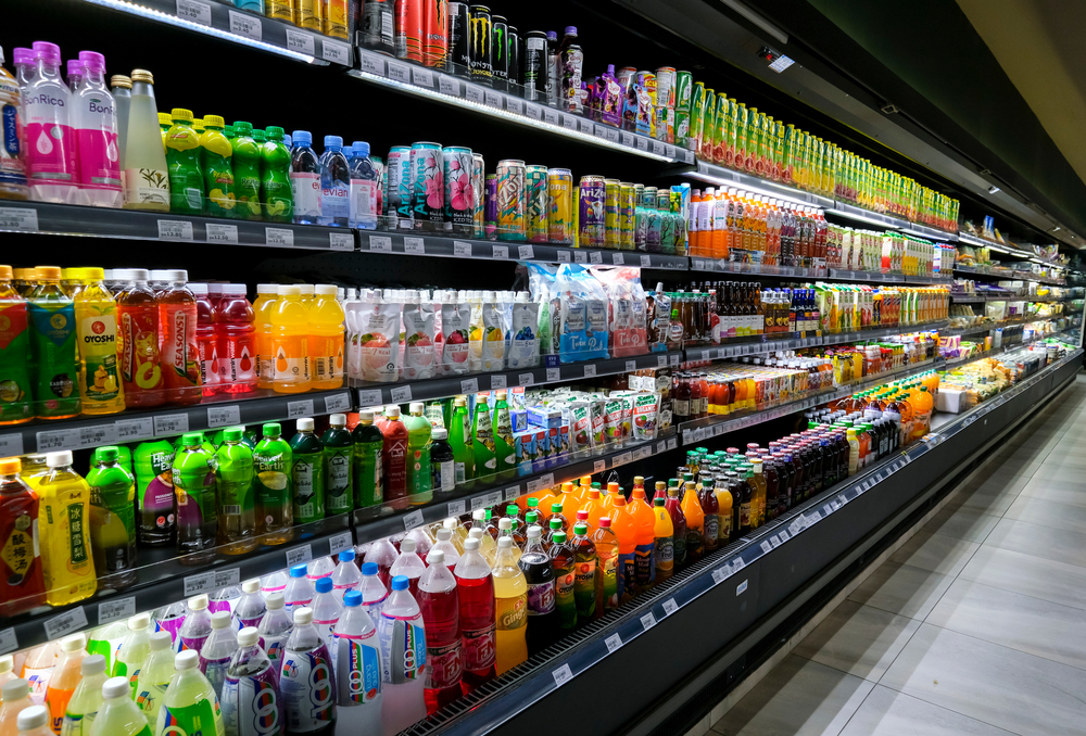 KUALA LUMPUR, MALAYSIA - MAY 04, 2020: Variety of energy drinks, soda, soft drinks, fruit juice, non-carbonated, in bottles and cans on the shelves in a grocery store supermarket. Beverages industry.