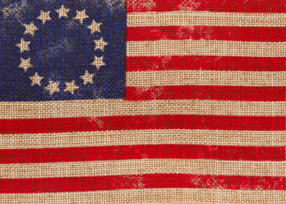 Old vintage Betsy Ross American flag with stars in a circle on burlap background