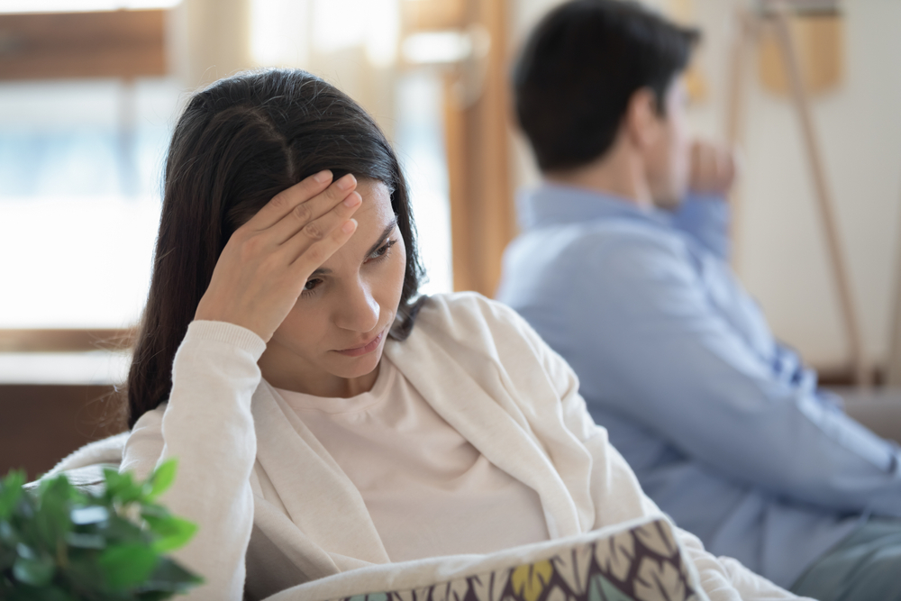 Emotional annoyed stressed couple sitting on couch, arguing at home. Angry irritated nervous woman man shouting at each other, figuring out relations, feeling outraged, relationship problems concept.