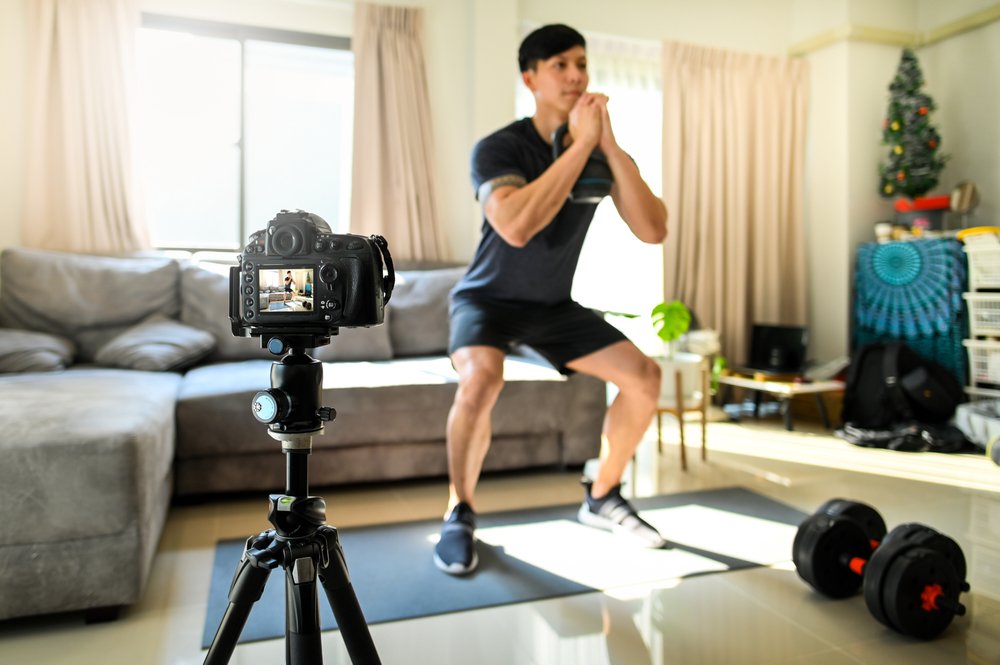 Asia man influencer recording video Exercises at Home for his blog.