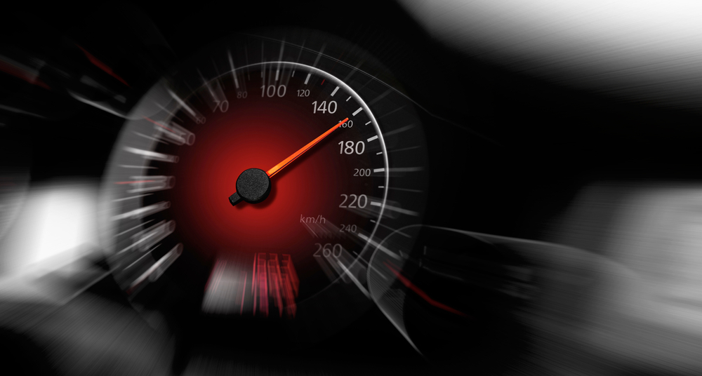 The speedometer of a modern car shows a high driving speed. Added motion blur.