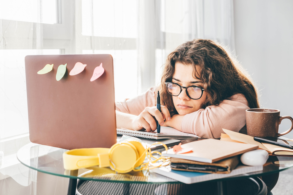 Bored woman studying at home. Student learning and working at home.